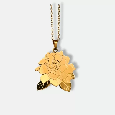 Gold pendant with a hand-drawn illustration of a flower and custom engraving