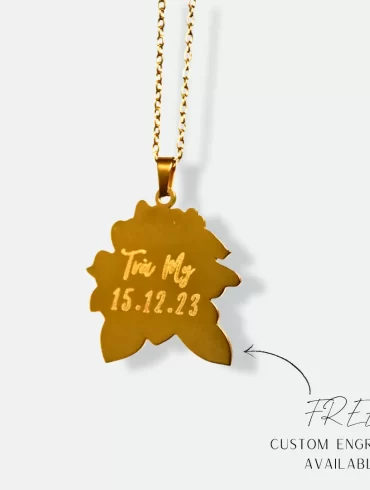 Gold pendant with a hand-drawn illustration of a flower and custom engraving