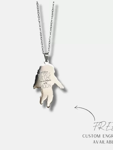 Silver pendant with a detailed astronaut design and engraved inspirational quote